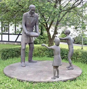 Raiffeisen distribuant du pain aux nécessiteux. Monument à Weyerbusch. © Photo B. S.